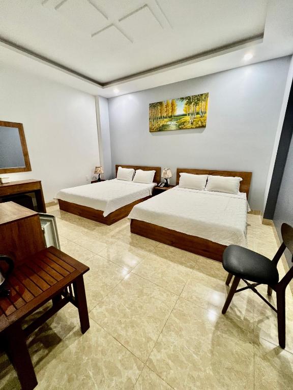邦美蜀Khách Sạn Trung Anh 78 HAI BÀ TRƯNG BMT的酒店客房,配有两张床和椅子