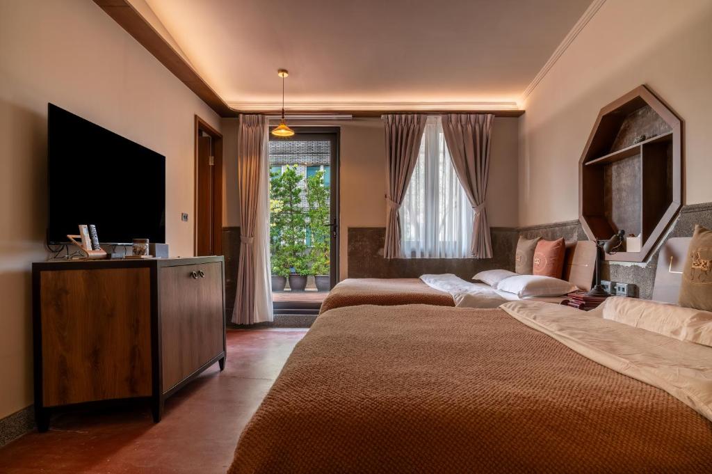 基隆安樓文旅Enzo House的酒店客房设有两张床和一台平面电视。