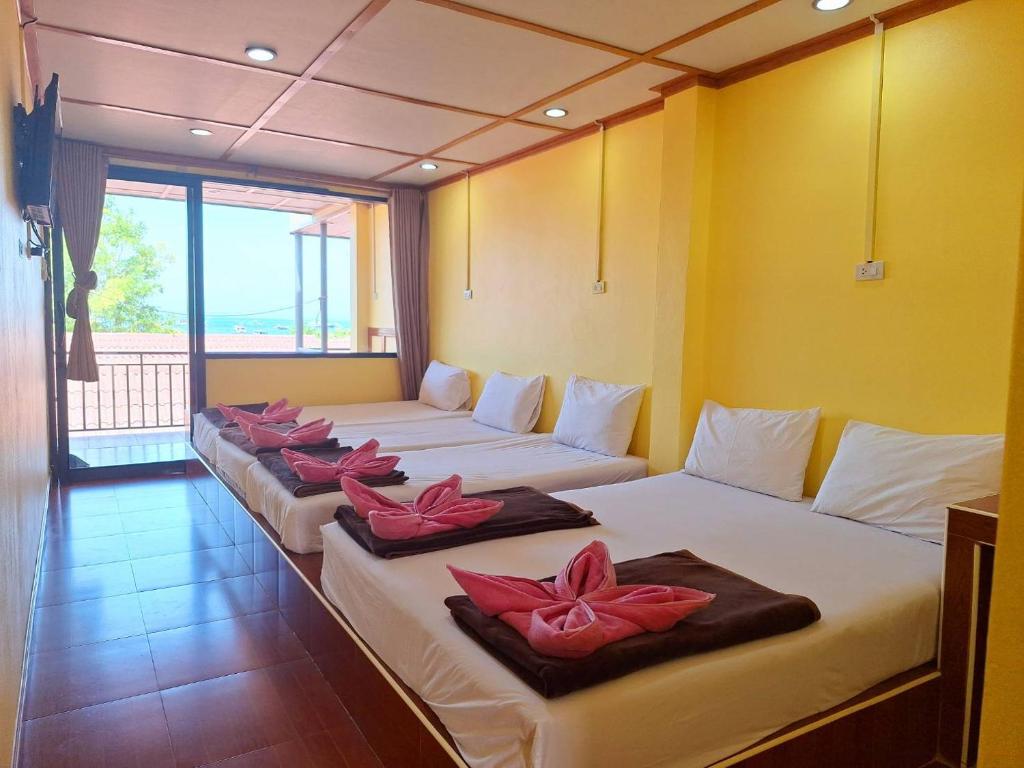 皮皮岛皮皮沙海景度假村 的一间设有四张床的客房,床上摆放着粉红色的鲜花