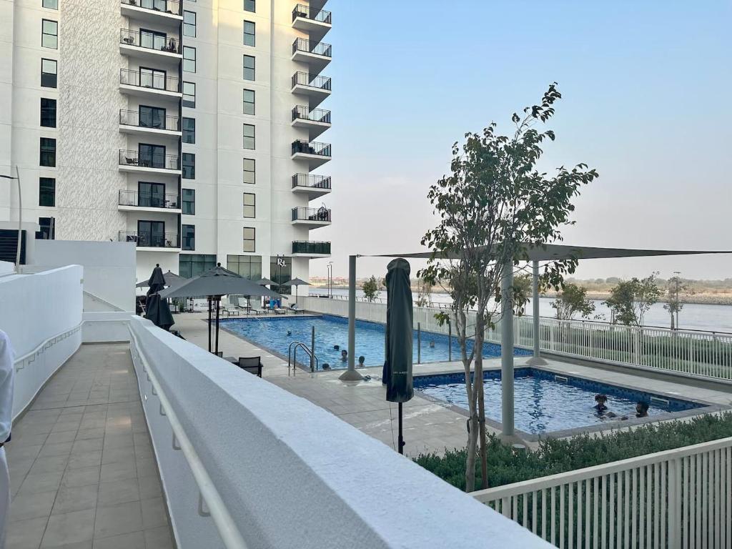 阿布扎比Hala Homes Yas Island- 1br的大楼阳台上的游泳池
