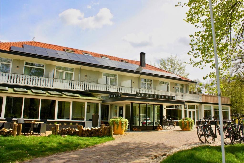 阿珀尔多伦Hotel Oranjeoord的一座大型建筑,上面有太阳能电池板
