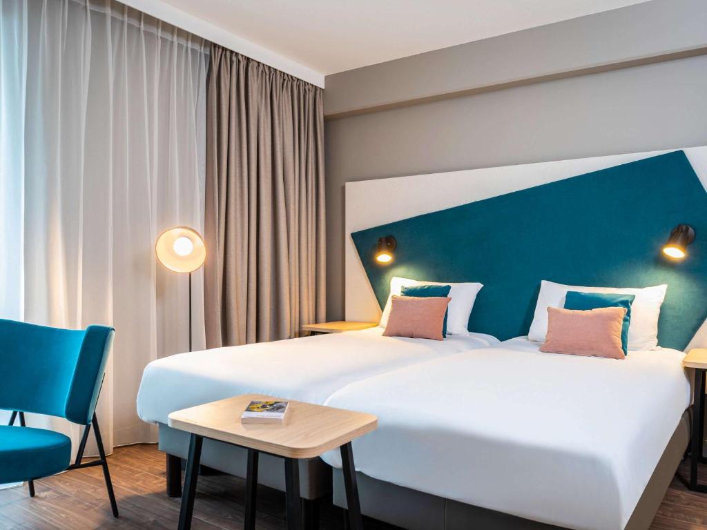 海德堡Aparthotel Adagio Heidelberg的酒店客房设有一张大床和一张桌子。