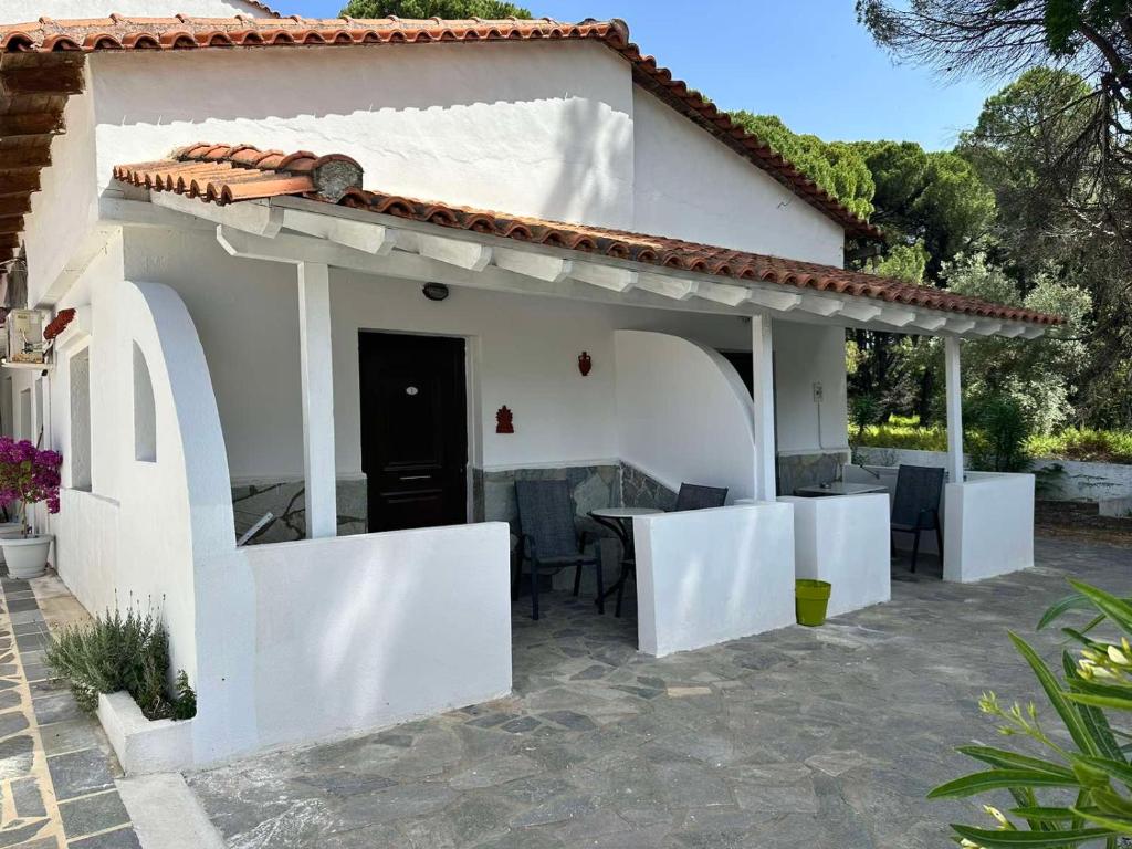 考考纳里斯Villa Nikos Koukounaries的前面有一张桌子的白色房子