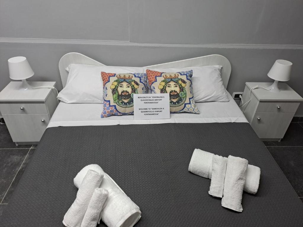 卡塔尼亚Esmeralda Il Quadrifoglio Airport Fontanarossa的一张带两条毛巾的床,带两个床头柜