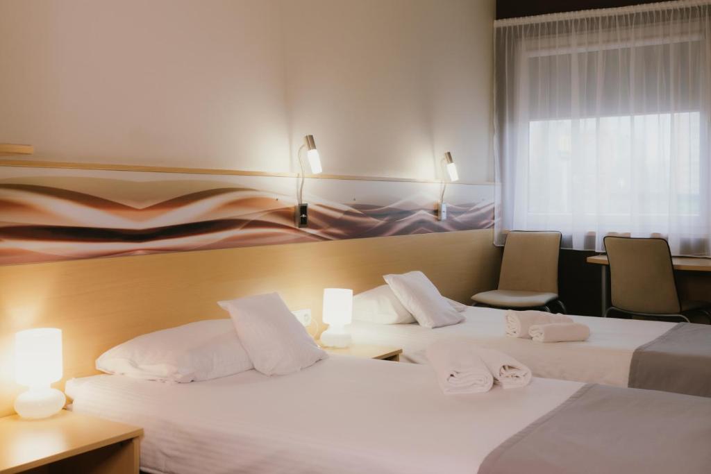 卡托维兹西里西亚品质酒店的酒店客房,配有两张床和两把椅子