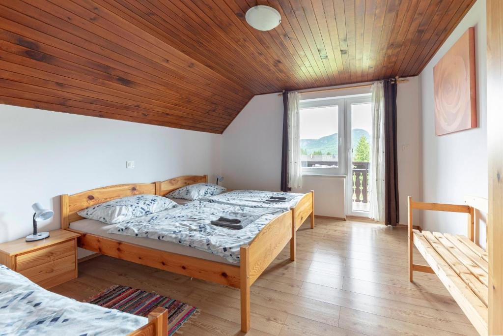 博希尼博尔公寓的一间卧室设有两张床和木制天花板