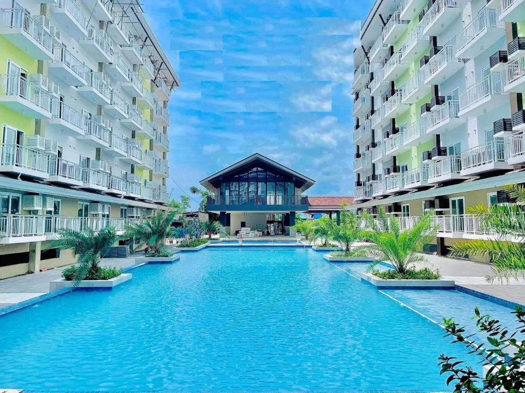 PusokVP - Amani Grand Resort Residences, 03 Minutes Away From Mactan Airport - Bldg B - Unit 522的两个公寓大楼中间的一个游泳池