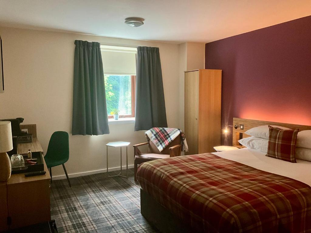 爱丁堡大不列颠爱丁堡酒店的酒店的客房 - 带一张床、椅子和窗户