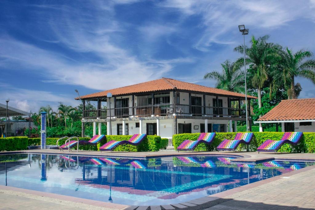亚美尼亚Finca Hotel Palmas Del Edén的一座带游泳池的度假村,位于一座建筑前