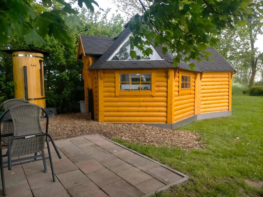 DoezumSterrenzicht BB Weidszicht的一间黄色的小小屋,设有黑色屋顶