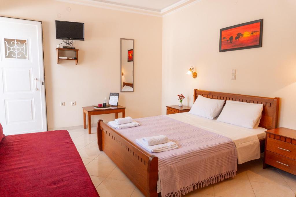 普雷韦扎Apartments Vasileiou Suite 2的一间卧室配有一张大床和红色地毯。