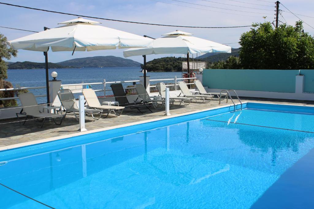 奈德里Tropicana Inn的一个带椅子和遮阳伞的游泳池