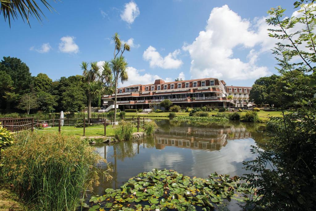 圣彼得港世界圣皮埃尔公园酒店&高尔夫球场的一座建筑前有池塘的酒店