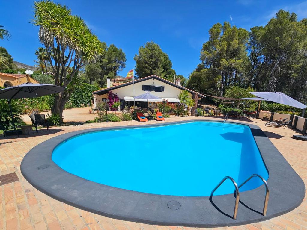 翁蒂年特Finca la Yuca的一座大蓝色游泳池,位于房子前
