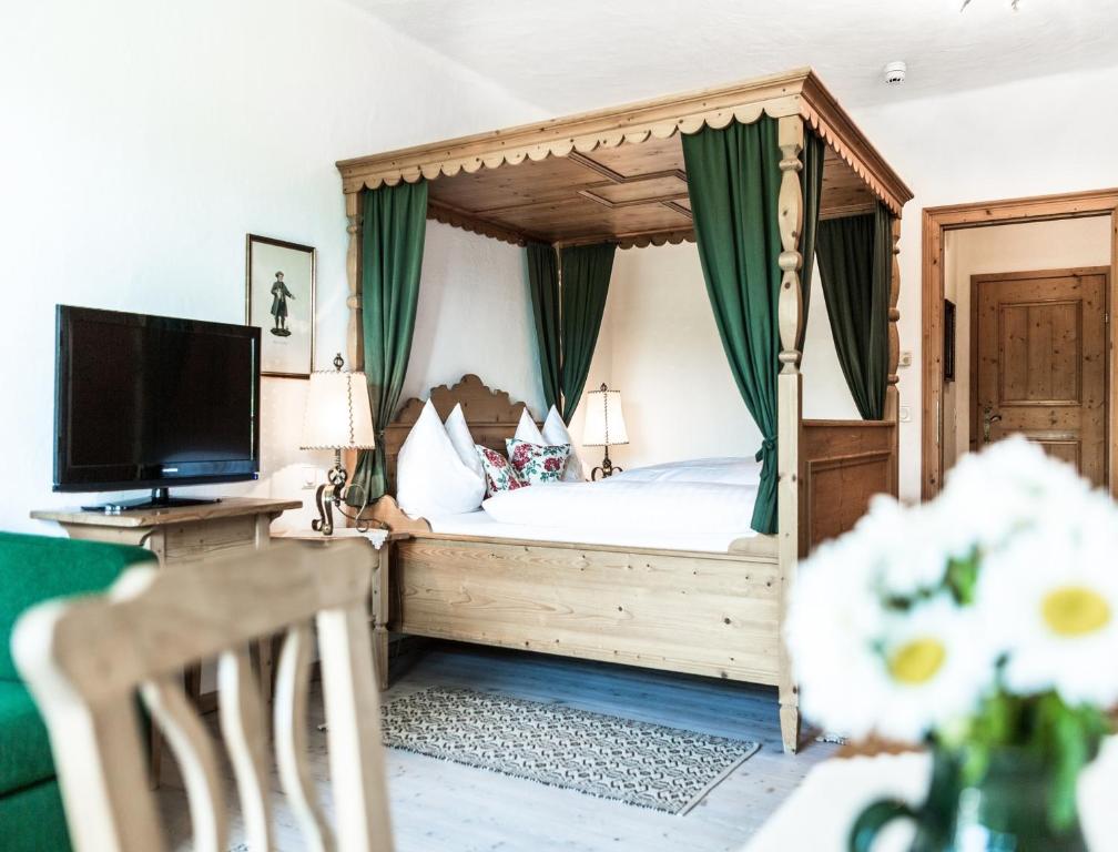 奥伊根多夫萨尔茨堡豪尔兹纳维尔特酒店的一间卧室设有一张天蓬床和电视。