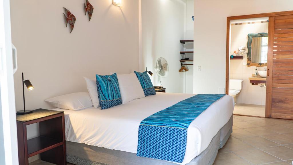 阿约拉港加拉帕戈斯套房住宿加早餐旅馆的一间卧室配有一张带蓝色和白色枕头的床