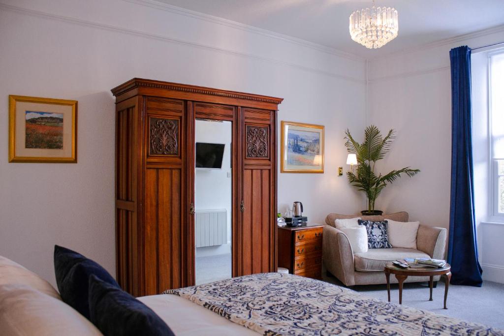 托基Gresham Court的一间卧室配有大型木制橱柜和椅子
