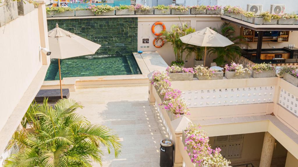 卡塔赫纳Hotel Casa Canabal by Faranda Boutique的享有带游泳池和遮阳伞的大楼的顶部景致