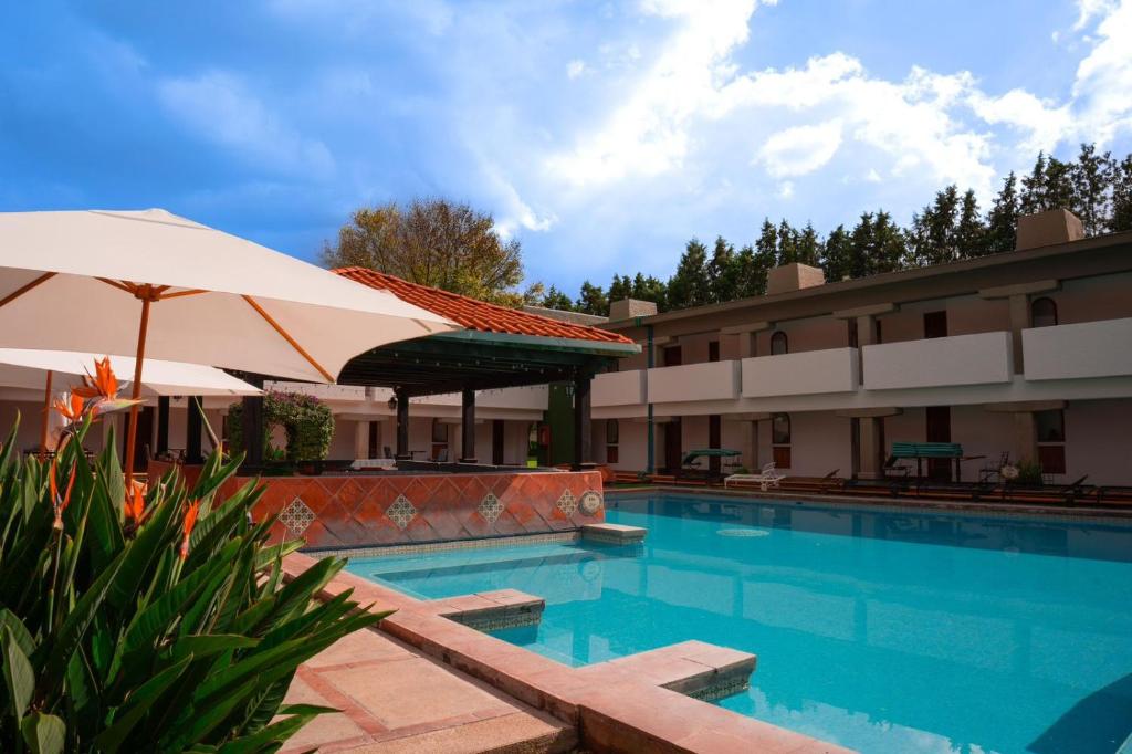 乔卢拉乔卢拉考古别墅酒店的酒店旁的游泳池配有遮阳伞