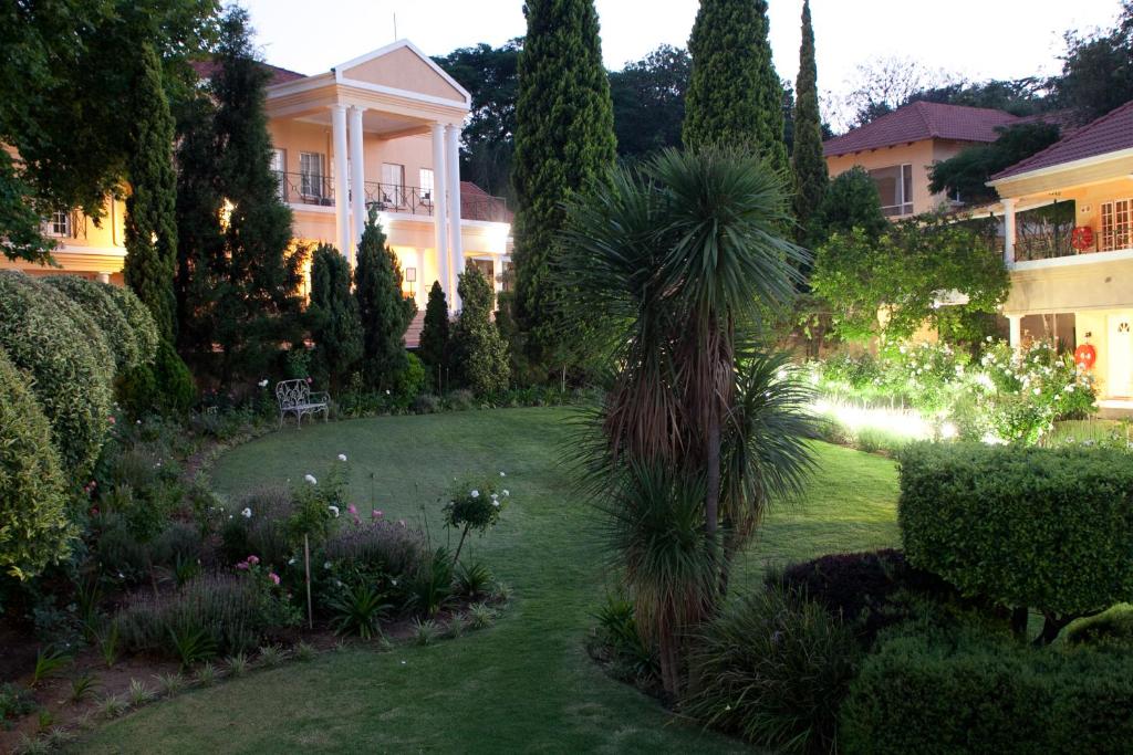 约翰内斯堡小托斯卡纳精品酒店的棕榈树屋前的花园