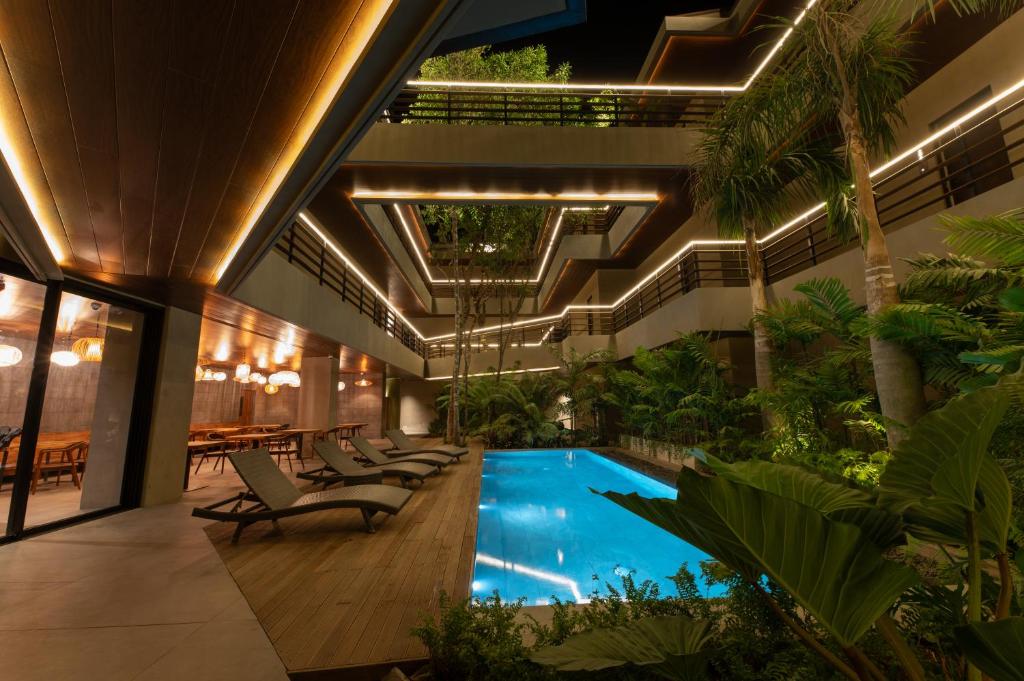 爱妮岛Piece Lio Resort from Japan的一座室内游泳池,位于一座带椅子和植物的建筑中