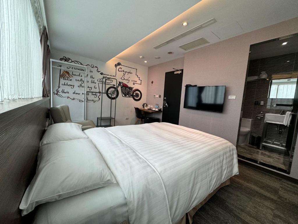 台北RF富裕自由旅店 - 林森馆的卧室配有一张白色大床和电视。