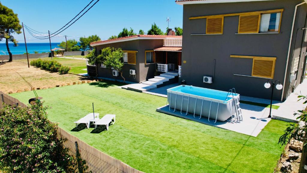 斯卡拉Gazonia Family Estate的一个带游泳池和房子的庭院