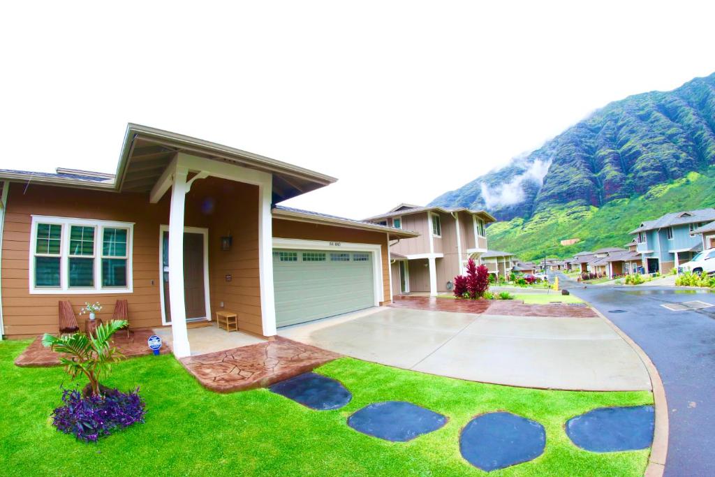 WaianaeNew 4 Bedroom Home with Ocean and Gorgeous Mountain Views in the gated community of Mauna Olu的山前有车道的房子