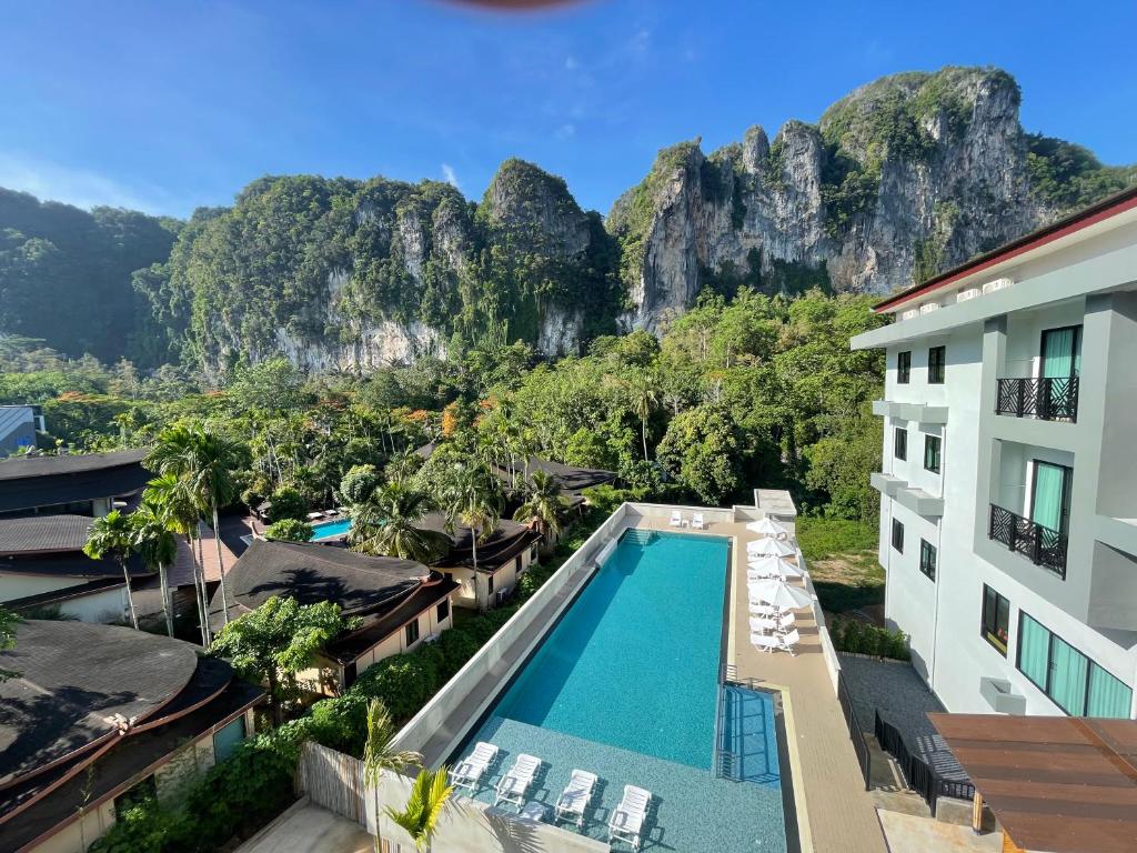 奥南海滩Keereen Resort - Ao Nang Krabi的背景为游泳池和山脉的酒店