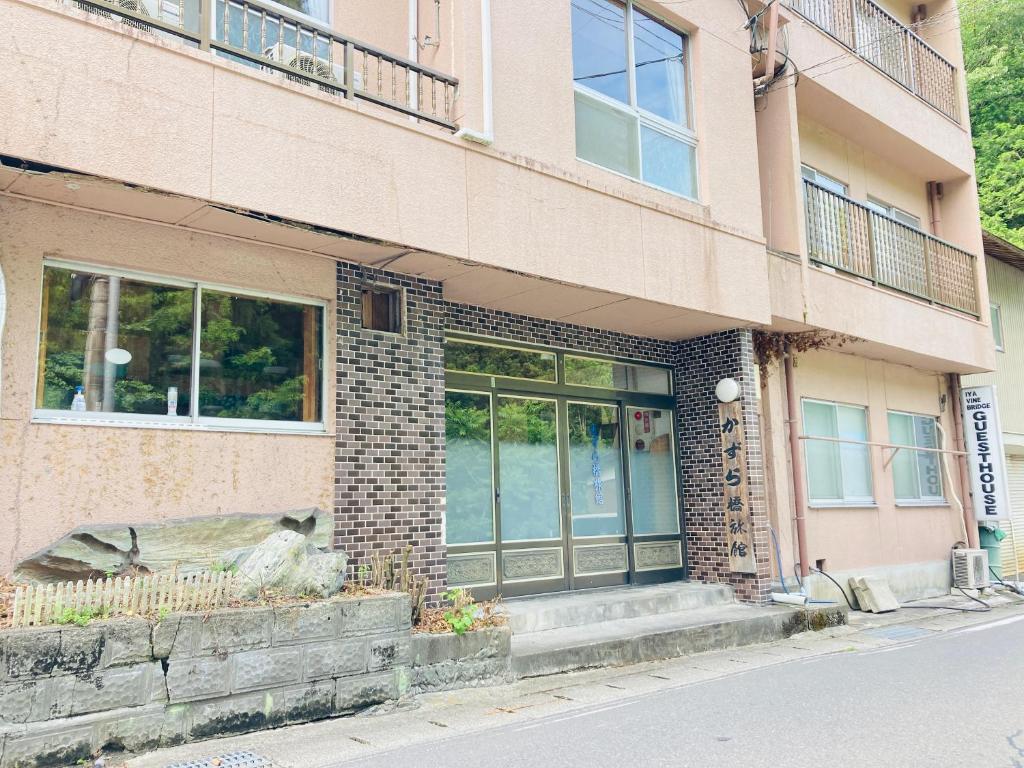 三好市Guesthouse KAZURABASHI的砖砌建筑,设有大玻璃门