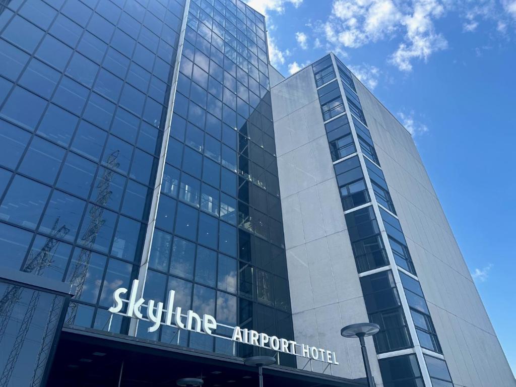 万塔Skyline Airport Hotel的一座高大的玻璃建筑,上面有标志