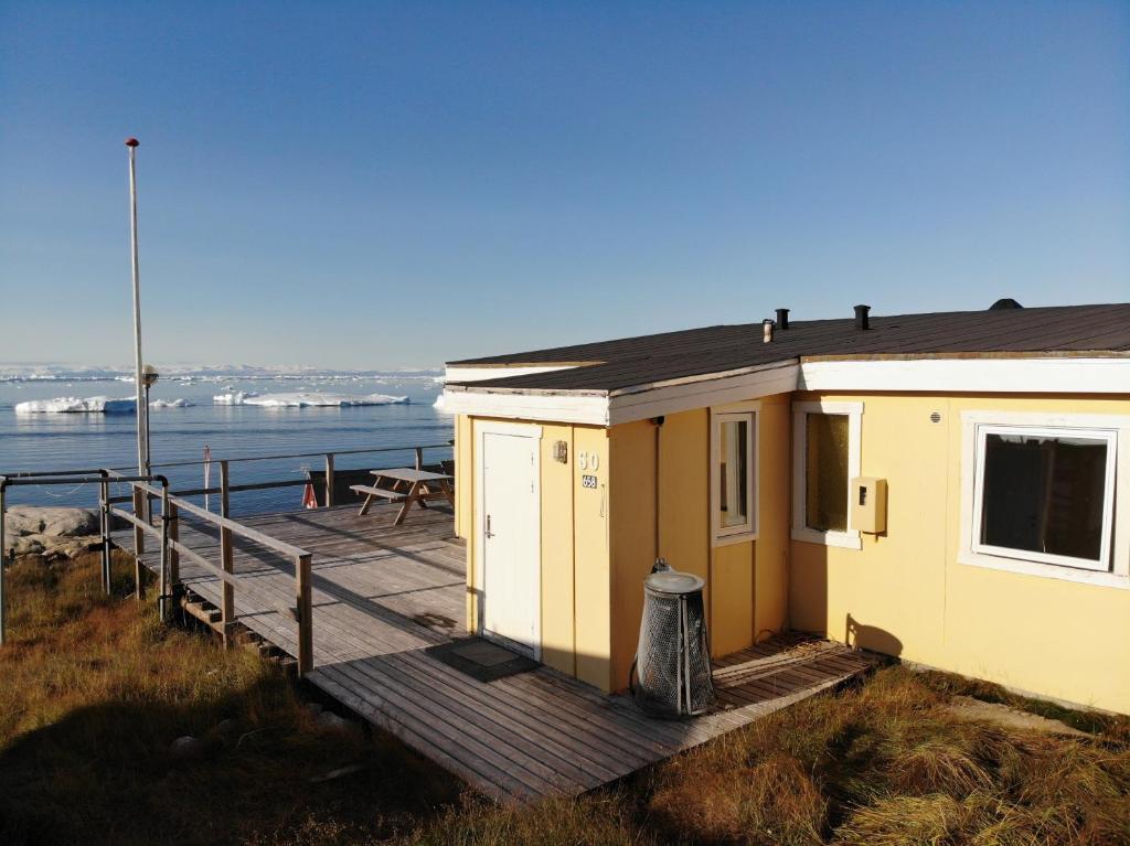 伊卢利萨特Grand seaview vacation house, Ilulissat的水边木板路上的小房子