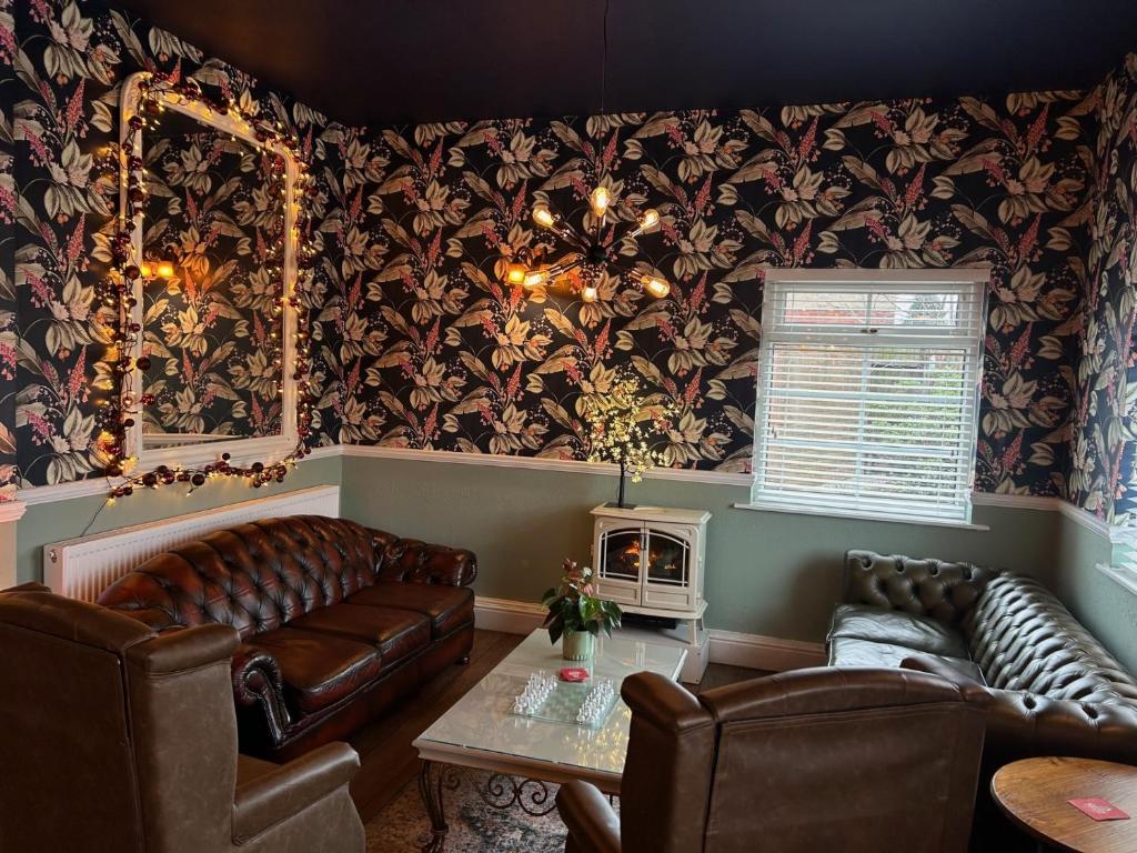 亚瑟斯通Blue Boar Inn的客厅配有皮革家具和壁纸