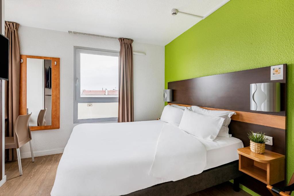 里昂普瑞米尔里昂中央车站经典酒店的卧室配有白色的床和绿色的墙壁