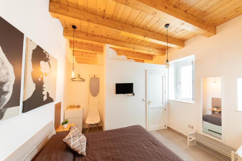 锡拉库扎Dolce Rame Ortigia的卧室配有一张床,墙上配有电视。