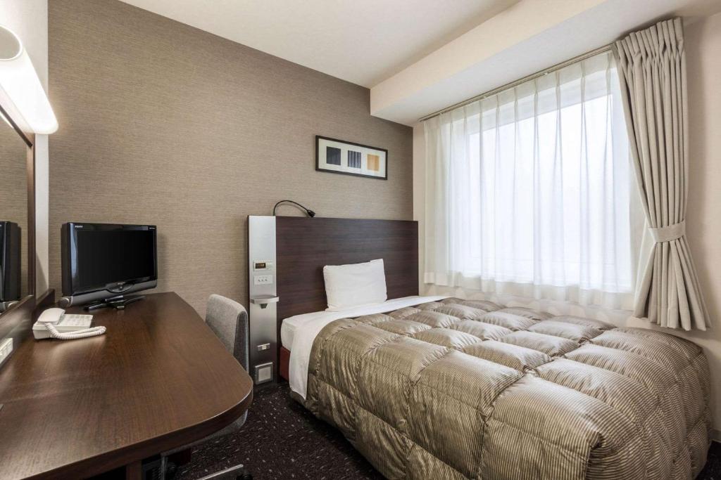 刈谷市刈谷舒适酒店的配有一张床和一张书桌的酒店客房