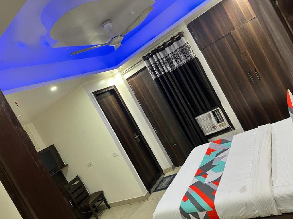 新德里Hotel Classic Suites的一间卧室设有一张床和蓝色的天花板