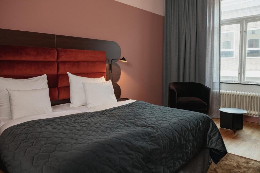 厄勒布鲁厄勒布鲁克拉丽奥酒店的配有一张床和一把椅子的酒店客房