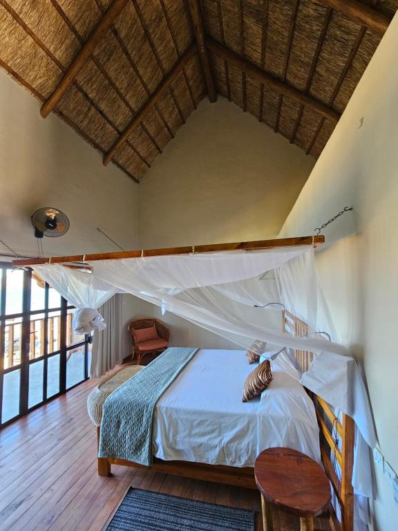 SengaJoma Adventure Lodge的一间卧室配有一张床,铺有木地板