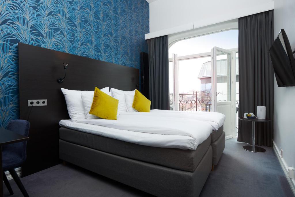 卡尔斯塔德广场克拉丽奥酒店的一间卧室配有一张带黄色枕头的大床