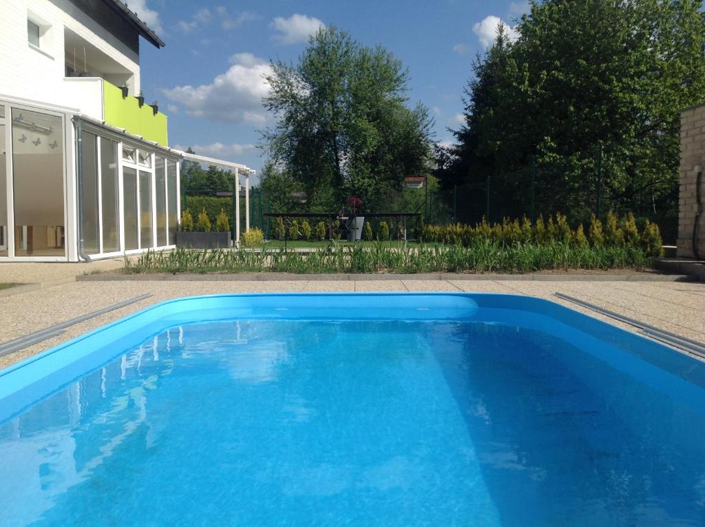 Kladenské RovnéPenzion Zelená zahrada的房子前面的蓝色游泳池