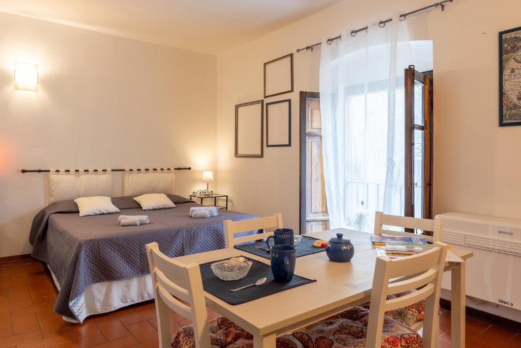 布奇内La casina di Tina的一间卧室配有一张床铺和一张桌子,还有一间用餐室