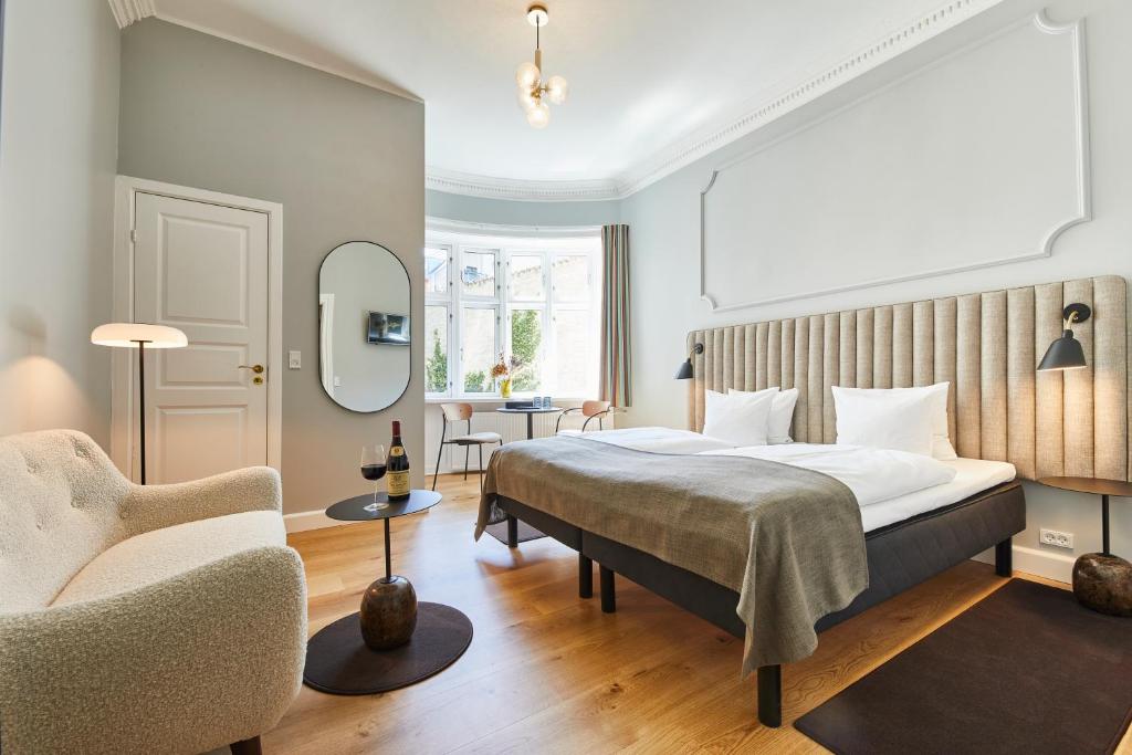 哥本哈根斯卡特托马斯酒店的配有一张床和一把椅子的酒店客房