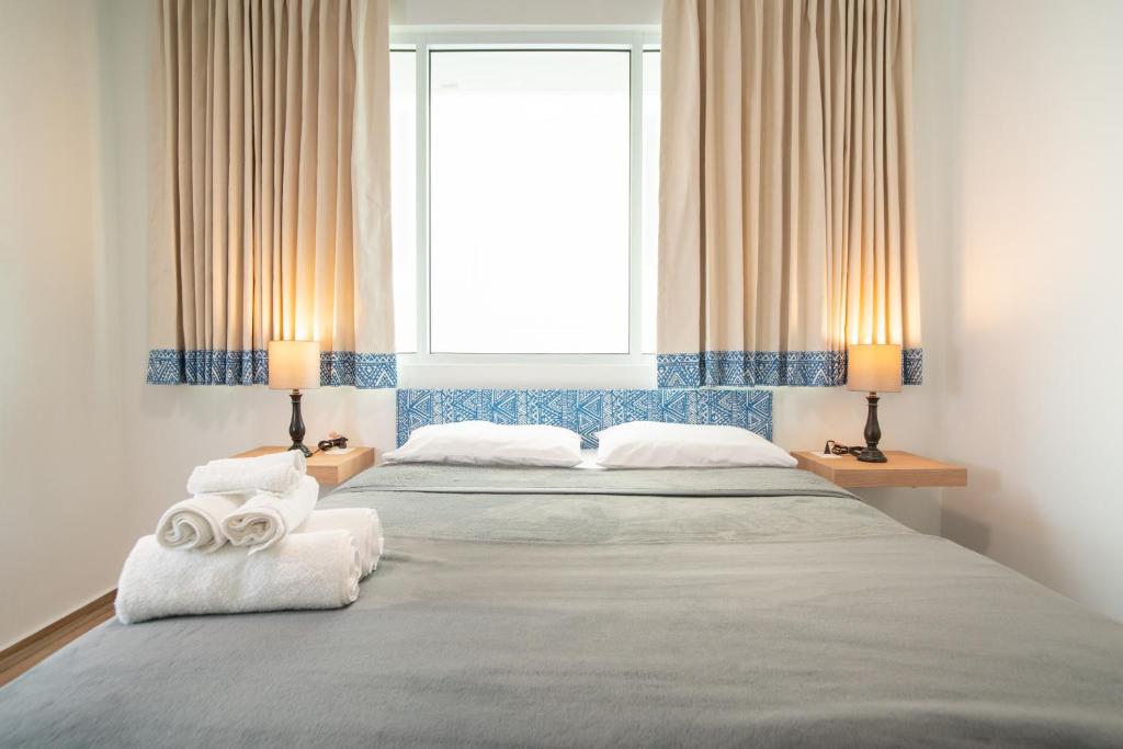 圣胡安卡萨康大多酒店的一间卧室配有两张床、毛巾和窗户