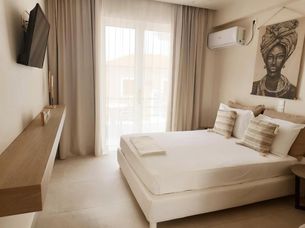 斯卡拉Akrogiali的卧室设有白色的床和大窗户