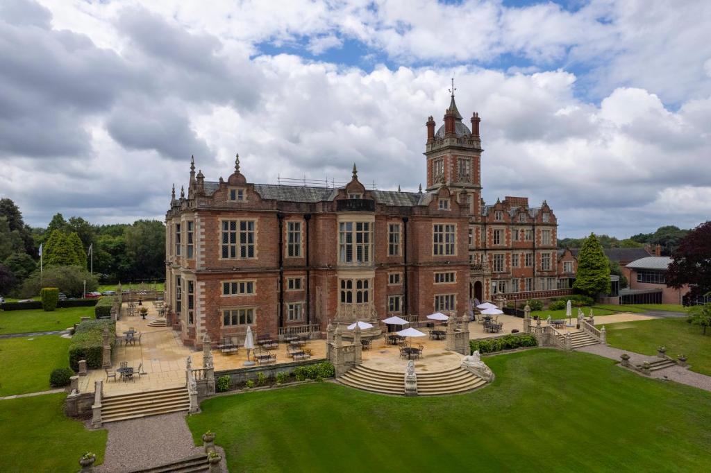 克鲁Crewe Hall Hotel & Spa - Cheshire的一座大型砖砌建筑,顶部设有钟楼