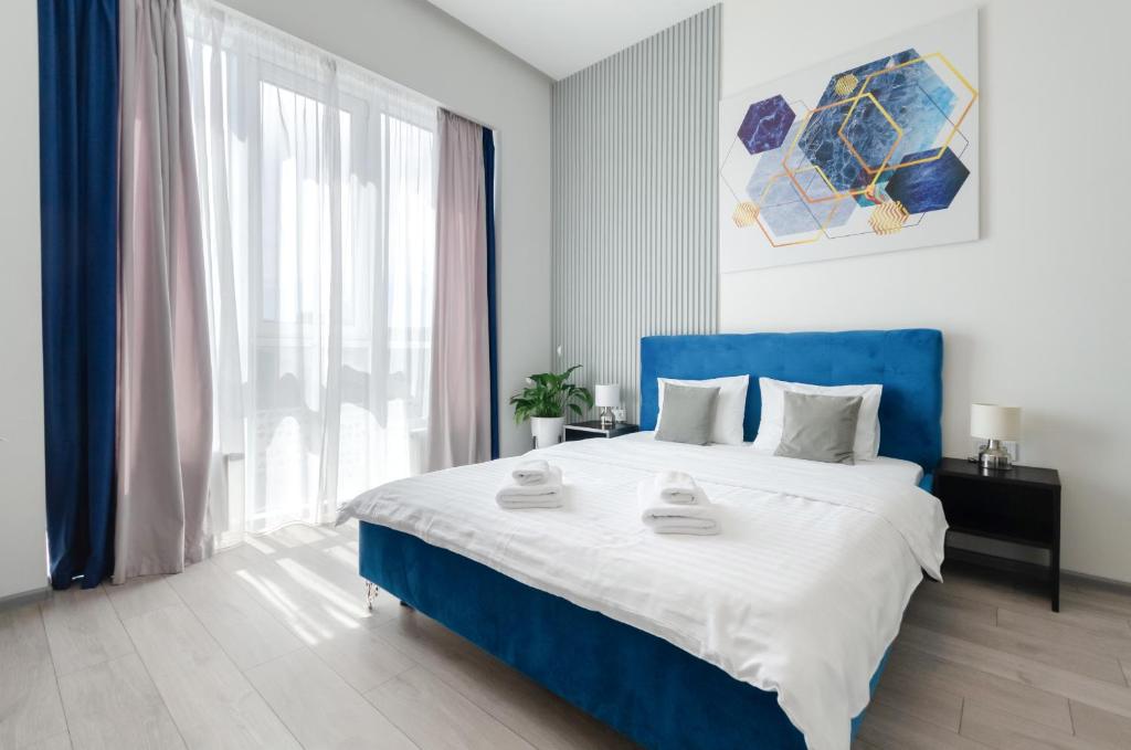 基辅Smart App near Railway Station Kvartet 3C的一间卧室设有蓝色的床和大窗户