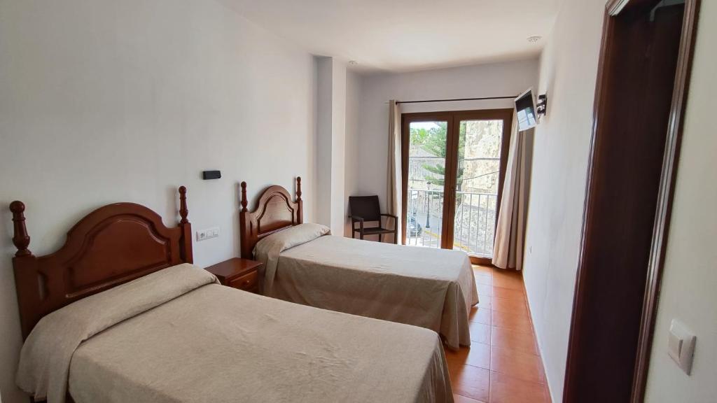 萨阿拉德洛斯阿图内斯Hostal Jadraza的客房设有两张床和窗户。
