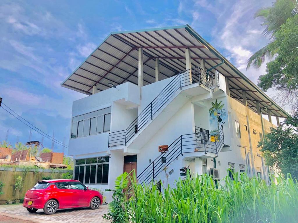 尼甘布Ceylon Lodge - Airport Transit Hotel & Hostel的停在房子前面的红色汽车