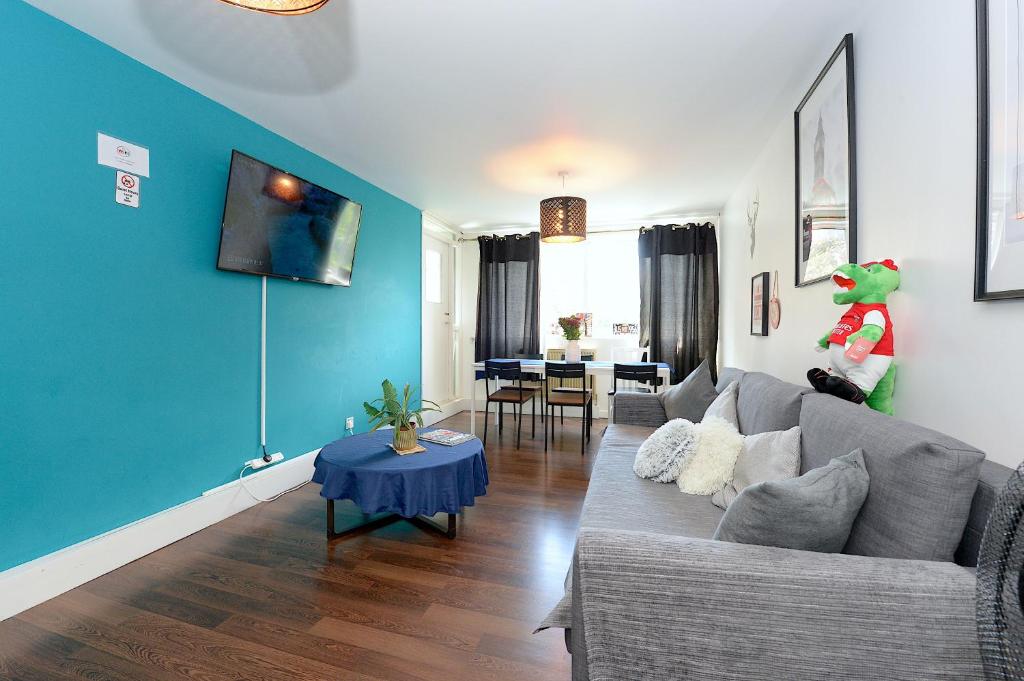 伦敦3 BEDROOM FLAT IN CENTRAL LONDON - REGENTS PARK / BAKER ST的客厅设有灰色的沙发和蓝色的墙壁